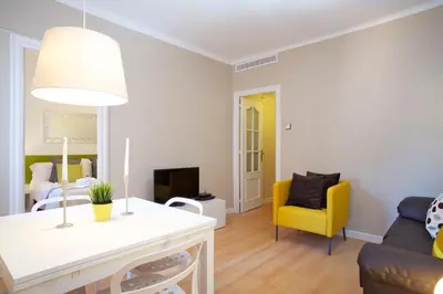 a living room with a table and a yellow chair at Sagrada Penthouse in Barcelona