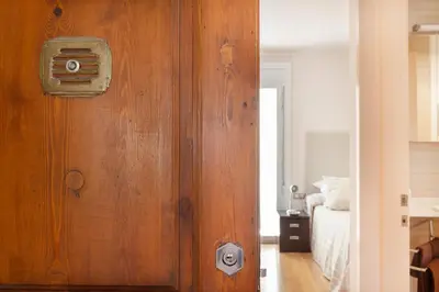 a wooden door in a bedroom with a bed at Dream Gracia Apartments in Barcelona
