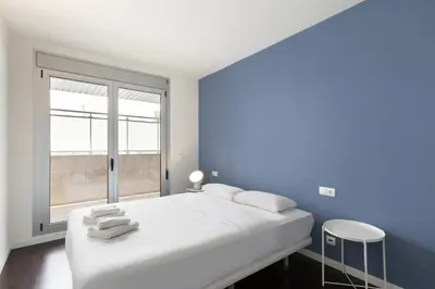 a bedroom with a large white bed and a window at Port Forum Apartments by Olala Homes in Sant Adria de Besos