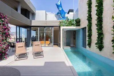a house with a swimming pool and two chairs at Cosmo Suite Penthouse in Barcelona