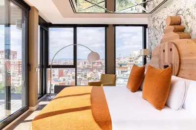 a bedroom with a bed and large windows at Cosmo Suite Penthouse in Barcelona