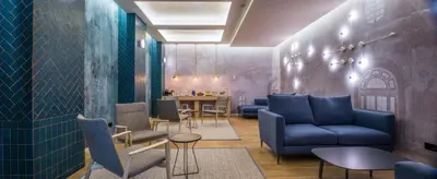 a waiting room with blue couches and a table at Sleep&Fly in El Prat de Llobregat