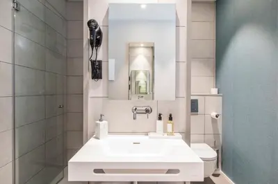 a white bathroom with a sink and a toilet at Sleep&Fly in El Prat de Llobregat