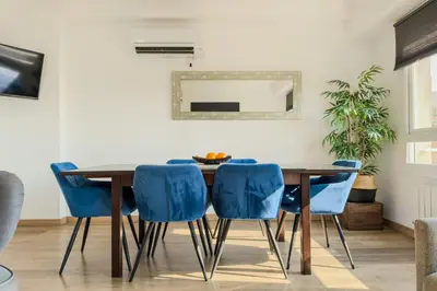 a dining room with a wooden table and blue chairs at Penthouse City Center With 2 Terraces And Views in Barcelona