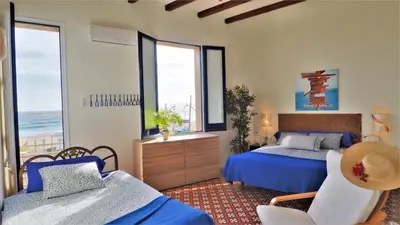 a bedroom with a bed and a couch and windows at MARISOL SEAVIEW & BEACH - apartment in Masnou