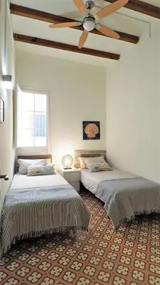 two beds in a room with a ceiling fan at MARISOL SEAVIEW & BEACH - apartment in Masnou