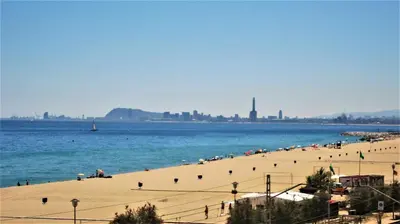 a beach with a bunch of people in the water at MARISOL SEAVIEW & BEACH - apartment in Masnou
