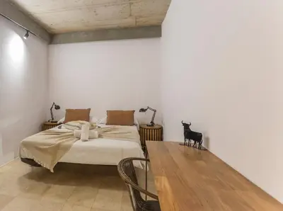 a bedroom with a bed and a wooden table at My Space Barcelona Pool City Center in Barcelona