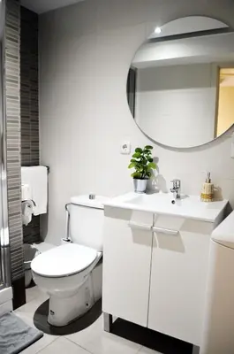 a white bathroom with a toilet and a mirror at Barcelona Mercaders Apartments in Barcelona