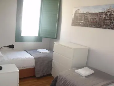 a small bedroom with two beds and a window at Barcelona Mercaders Apartments in Barcelona