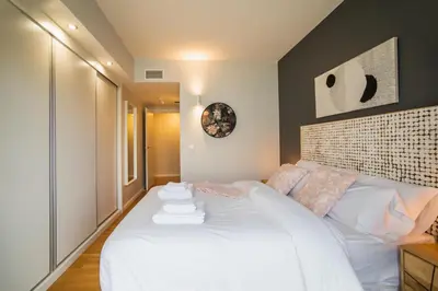 a bedroom with a large bed with white sheets at Tendency Apartments Forum in Sant Adria de Besos