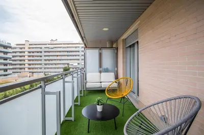 a balcony with two chairs and a table at Tendency Apartments Forum in Sant Adria de Besos