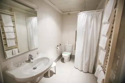 a white bathroom with a sink and a toilet at Gatell Hotel in Vilanova i la Geltrú