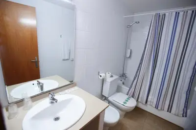 a bathroom with a sink and a toilet and a shower at Gatell Hotel in Vilanova i la Geltrú