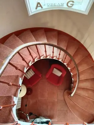 a spiral staircase with red chairs in a building at VILLA BELLA ESTANÇA in Castelldefels