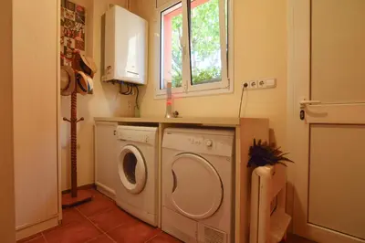 a laundry room with a washing machine and a window at VILLA BELLA ESTANÇA in Castelldefels