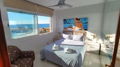 a bedroom with a bed and a chair and a window at CATALINA PORT & BEACH -3 dormitorios in Masnou