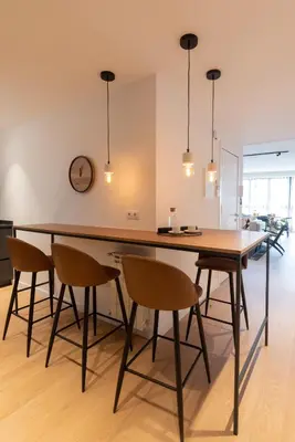 a dining room with a large wooden table and chairs at Petit Luxe l'Àtic in Terrassa