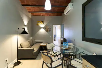 a living room with a glass table and a couch at Fira Apartments by gaiarooms in Barcelona