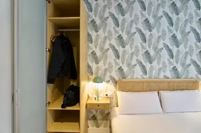 a bedroom with a bed with a lamp on a table at Fira Apartments by gaiarooms in Barcelona