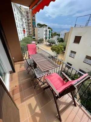 a balcony with a wooden table and two chairs at Apartamento con Licencia en Sitges in Sitges