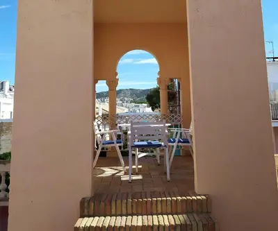 a balcony of a house with a table and chairs at Hotel Medium Renaixença in Sitges