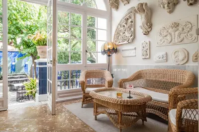 a living room with wicker chairs and a table at Hotel Medium Romantic in Sitges