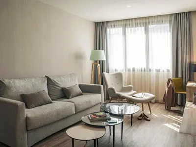 a living room with a couch and a table at Mercure Barcelona Condor in Barcelona