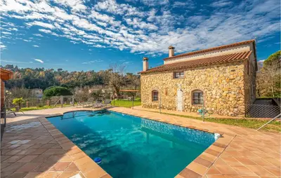 a stone house with a swimming pool in front of it at 4 Bedroom Nice Home In Riells I Viabrea in Breda