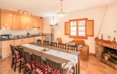 a kitchen and living room with a table and chairs at 4 Bedroom Nice Home In Riells I Viabrea in Breda