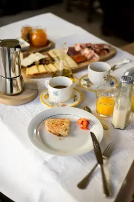 a table with a plate of food and cups of coffee at Mas Palou in Pla del Panadés