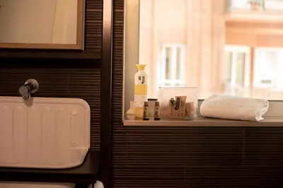 a bathroom with a sink and a window and a towel at Unite Hostel Barcelona in Barcelona