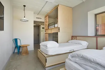 a bedroom with two beds and a table and a chair at Unite Hostel Barcelona in Barcelona