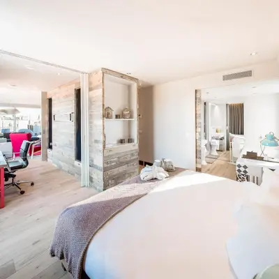 a bedroom with a large white bed and a desk at Generator Barcelona in Barcelona