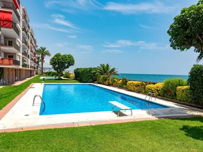 a swimming pool in a resort with the ocean in the background at Apartment Acuario by Interhome in Sant Andreu de Llavaneres