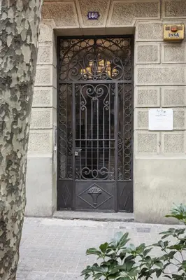 a black door on a building with a sign on it at AinB Eixample-Miro Apartments in Barcelona