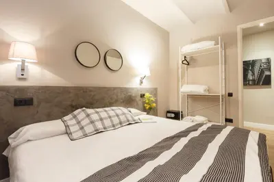 a bedroom with a bed with two mirrors on the wall at AinB Eixample-Miro Apartments in Barcelona