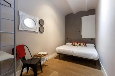 a small bedroom with a bed and a window at AinB Eixample-Miro Apartments in Barcelona