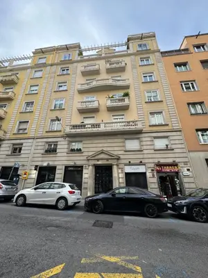 two cars parked in front of a large building at Pensión Laforja in Barcelona