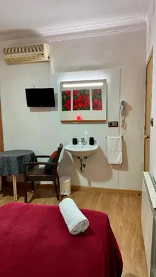 a room with a bed and a sink in a room at Pensión Laforja in Barcelona