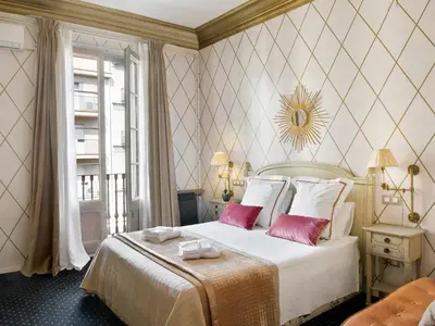 a bedroom with a large bed with two pink pillows at HoHomes - Centric Design Apartment in Barcelona