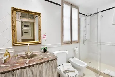 a bathroom with a sink and a toilet and a mirror at HoHomes - Centric Design Apartment in Barcelona