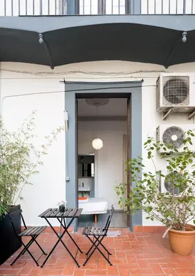 a patio with a black umbrella and a table at ZOOROOMS Boutique Guesthouse in Barcelona