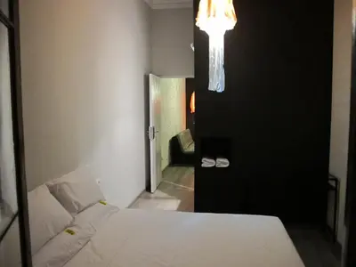 a bedroom with a bed and a room with a chandelier at ZOOROOMS Boutique Guesthouse in Barcelona