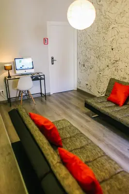 a living room with a couch and a desk with a computer at ZOOROOMS Boutique Guesthouse in Barcelona