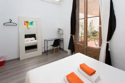 a white room with two beds and a window at ZOOROOMS Boutique Guesthouse in Barcelona