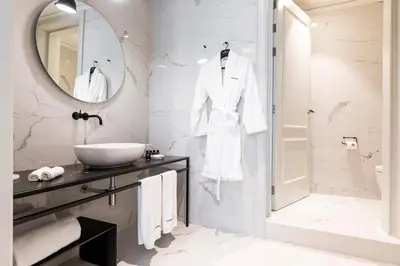 a white bathroom with a sink and a mirror at Maldà Singular Hotel in Barcelona