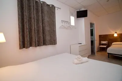 a bedroom with a white bed and a television at Hostal Martinval in Barcelona