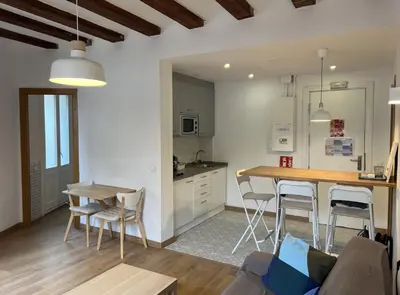 a kitchen and living room with a table and chairs at Ripoll Apartments in Barcelona