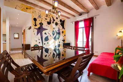 a dining room table with a clock on the wall at Apartamentos El Pintor in Barcelona